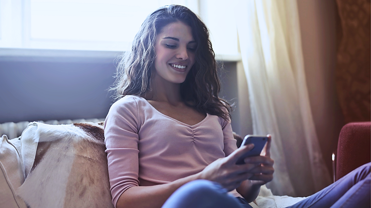 Videolearning - Frau mit Smartphone auf Sofa